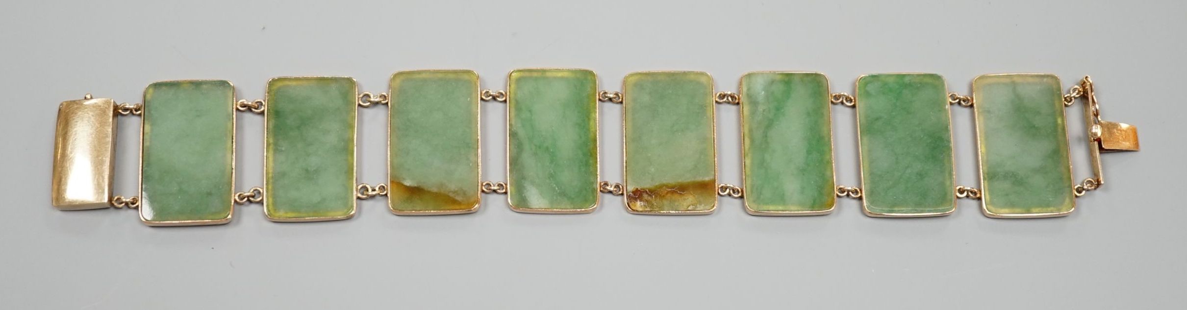 A 585 yellow metal and jade bracelet, set with eight rectangular panels, 18cm, gross weight 26.5 grams.